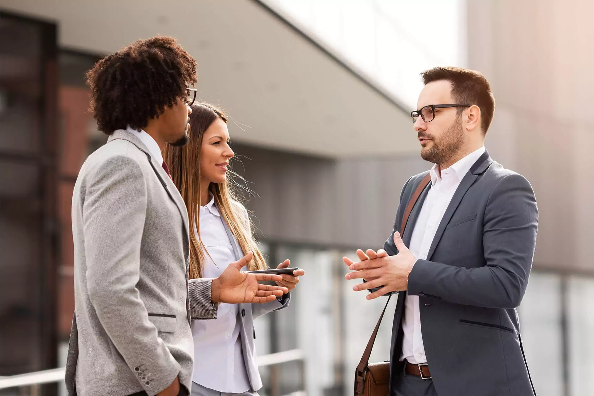 Man talking to coworkers outside